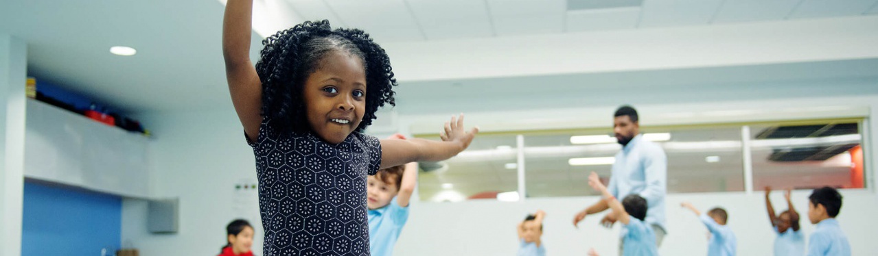 Photo-Kindermusik-PreK-BronxNY-AfricanAmerican-girl-dancing-hands-raised-smiling-6926x4622